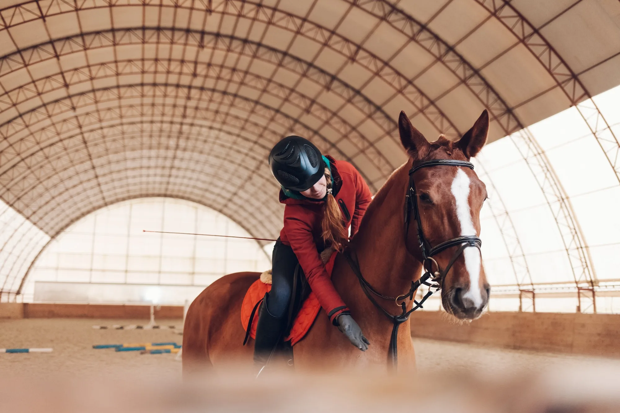 Pretty young woman riding a horse in the arena for equestrian sport